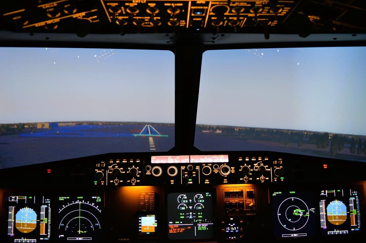 Airbus A320 simulator flight deck with the runway visual ahead and the instrument displays lit